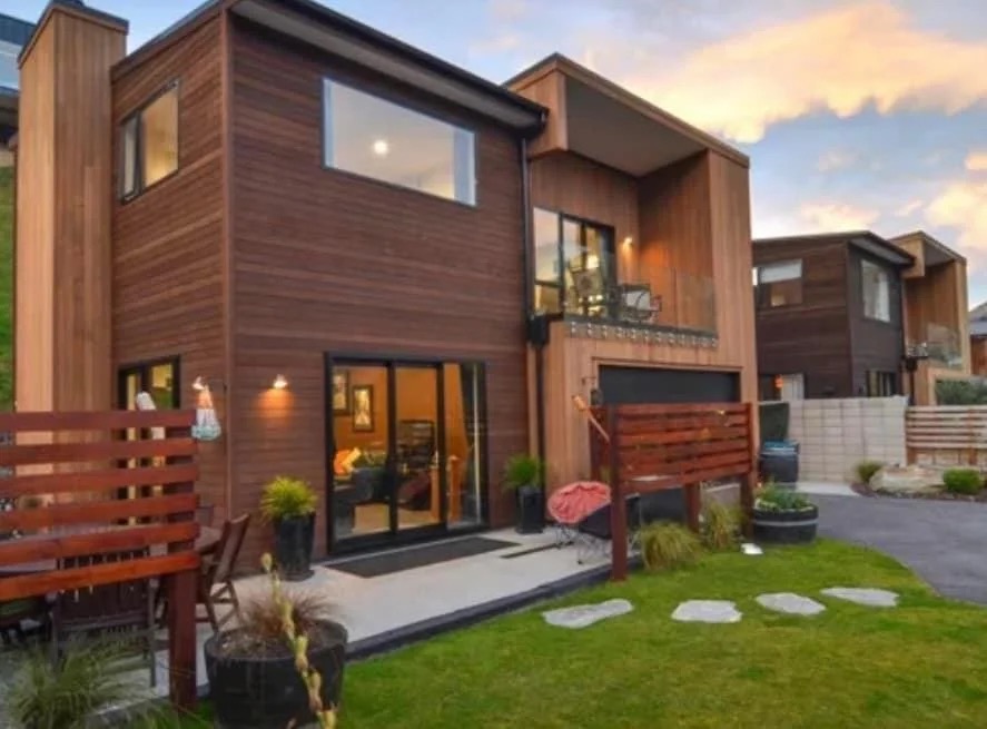 Timber single-level home at dusk with outdoor dining